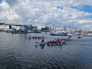 Three Dragon Boats racing in a heat Three Dragon Boats racing in a heat